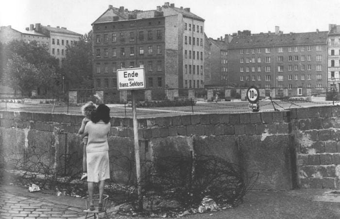 es milliers de Berlinois au désespoir se rassemblent, à la limite des secteurs, devant ce rempart qui, pour n’être encore composé que de barbelés et de chevaux de frise, ressemble déjà à un mur